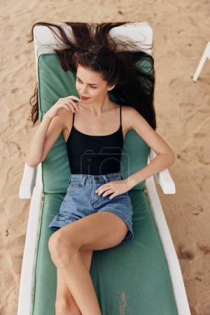 Foto de Mujer tumbona persona silla resort disfrutar de gafas de sol estilo de vida femenino sombrero bronceado hermosa arena sonriente océano playa acostado viaje mar relajarse playa caucásico - Imagen libre de derechos