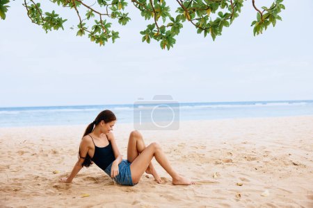 Foto de Mujer sentada solo feliz verano playa al aire libre hermoso atractivo adulto sexy mar viaje agua despreocupada arena sonrisa naturaleza bronceado vacaciones libertad - Imagen libre de derechos
