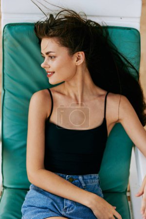 Foto de Mujer arena acostado estilo de vida océano atractivo traje de baño recreación persona viaje resort caucásico sonriente joven mar sunbed silla sol chica playa bronceado - Imagen libre de derechos