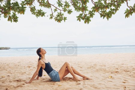 Téléchargez les photos : Femme plage liberté mer nature vacances eau attrayant joli Voyage soleil corps sourire assis jeune adulte côte sable détendre mode style de vie - en image libre de droit