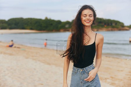 Foto de Playa mujer sonrisa al aire libre persona estilo de vida vacaciones disfrute puesta del sol arena hermoso vestido joven caucásico mar verano copia océano ocio espacio libre copia espacio - Imagen libre de derechos