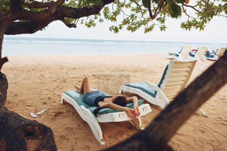 Foto de Mujer sombrero océano estilo de vida playa atractiva hamaca tumbada relajación playa joven sonriente relajarse silla gafas de sol exótico resort morena descansando arena bronceado mar - Imagen libre de derechos