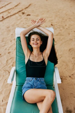 Foto de Mujer azul bikini resort arena tumbado silla sonriente playa estilo de vida sombrero océano viaje sentado sol cama playa mar traje de baño tropical - Imagen libre de derechos