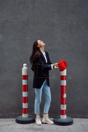 Photo for Fashion woman standing on the street in front of the city and road works tourist in stylish clothes with red lips and red beret, travel, cinematic color, retro vintage style. High quality photo - Royalty Free Image