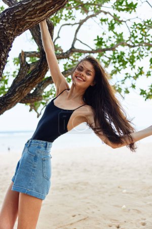 Foto de Bikini mujer árbol joven chica soleado relajarse belleza cielo yoga arena mirando mar colgando horizonte pelo estilo de vida naturaleza sonriendo océano vacaciones largo - Imagen libre de derechos