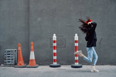 Foto de Mujer de moda corriendo por la calle frente al turista de la ciudad en ropa elegante con labios rojos y boina roja, viajes, color cinematográfico, estilo vintage retro, tarde al trabajo. Foto de alta calidad - Imagen libre de derechos