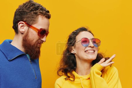 Foto de Pareja de hombres y mujeres sonriendo alegremente y torcidos con gafas, sobre fondo amarillo, símbolos signos y gestos de la mano, sesión familiar, recién casados. Foto de alta calidad - Imagen libre de derechos