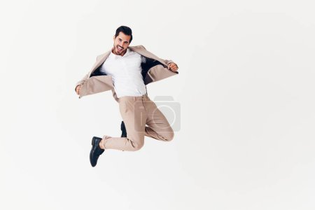 Photo for Man beige confident running sexy smiling professional suit job victory business happy flying adult attractive jumping winner isolated businessman standing office - Royalty Free Image