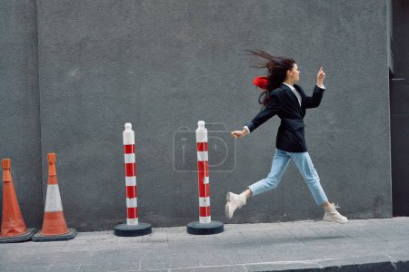Foto de Mujer de moda corriendo por la calle frente al turista de la ciudad en ropa elegante con labios rojos y boina roja, viajes, color cinematográfico, estilo vintage retro. Foto de alta calidad - Imagen libre de derechos