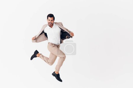 Foto de Hombre sonriendo feliz blanco negocio ganador camisa volando corriendo sonrisa trabajo alegre modelo sexy chaqueta de pie estudio traje victoria hombre de negocios beige volando - Imagen libre de derechos