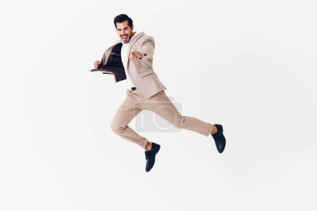 Téléchargez les photos : Homme joyeux gagnant sexy souriant beige costume portrait studio de travail jeune homme d'affaires emploi volant homme sourire personne course victoire heureux - en image libre de droit