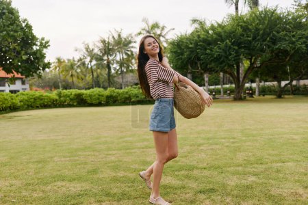 Téléchargez les photos : Relax femme parc hipster promenade insouciante herbe sourire bali beau souriant style de vie t-shirt naturel noir été joie nature exercice liberté - en image libre de droit