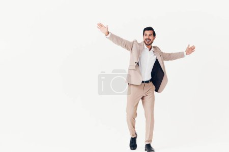 Téléchargez les photos : Homme d'affaires jeune lunettes beige debout élégant occupation succès barbe isolé courir vol homme d'affaires souriant victoire costume studio gagnant blanc heureux - en image libre de droit