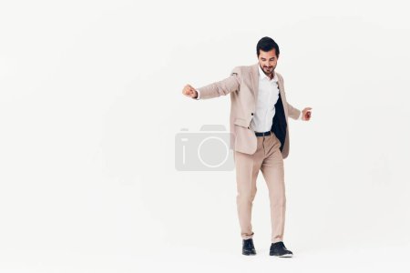 Téléchargez les photos : Homme gai beige succès élégant costume d'affaires heureux studio sautant sourire travail souriant modèle en cours d'exécution homme d'affaires personne victoire homme chemise gagnant - en image libre de droit