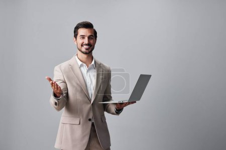 Téléchargez les photos : Homme d'affaires ordinateur réseau ordinateur portable pigiste travailler personne en ligne fond internet entreprise emploi sourire gars barbe sans fil copyspace jeune heureux beige costume - en image libre de droit