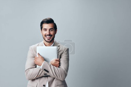 Téléchargez les photos : Homme élégant ordinateur portable numérique personne ordinateur entreprise emploi beige chemise entrepreneur copyspace souriant internet barbe costume adulte pigiste joyeux réseau bureau - en image libre de droit