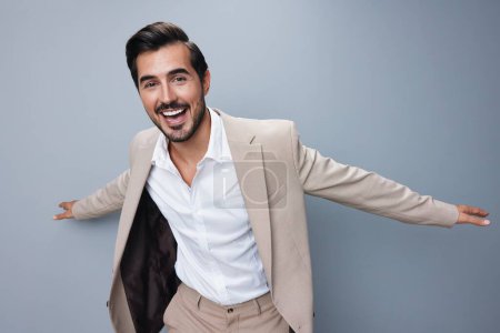 Photo for Victory man isolated businessman studio cheerful male happy up smiling success shirt arm stylish hand winner beige work suit model business - Royalty Free Image
