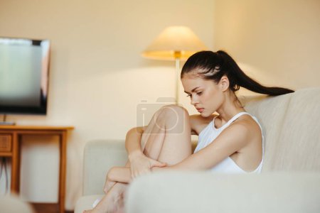 Photo for Sad woman depressed sitting on the couch at home, anxiety disorder alone without the help of a psychologist. High quality photo - Royalty Free Image