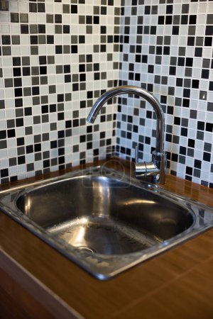 Téléchargez les photos : Évier propre avec de l'eau à verser dans la cuisine, robinet en métal et évier dans un ancien intérieur de la maison. Photo de haute qualité - en image libre de droit