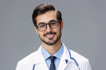 Photo for Male doctor in a white coat and glasses for vision and a stethoscope looks at the camera smile with teeth dentist on a gray isolated background, copy space, space for text, health. High quality photo - Royalty Free Image