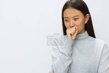 Téléchargez les photos : Femme asiatique tenant sa main à la tête et toussant la grippe et le rhume, la maladie virale covid 19 fond blanc. Photo de haute qualité - en image libre de droit