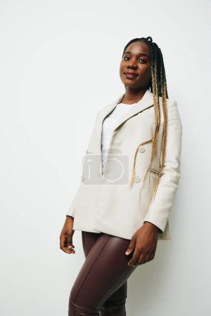 Téléchargez les photos : Portrait de femme d'affaires afro-américaine, vêtements d'affaires et veste avec des tresses afro sourire. Fond blanc. Couleurs douces et chaudes. Photo de haute qualité - en image libre de droit