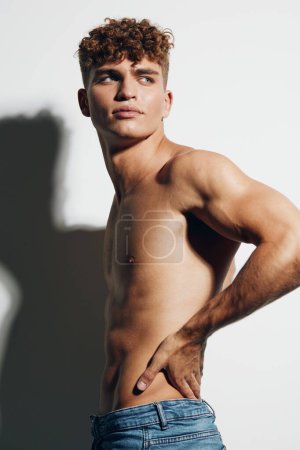Foto de Hombre ajuste cuerpo adulto atleta estilo de vida bíceps persona muscular cuidado blanco fondo gris fondo hermoso atlético jeans - Imagen libre de derechos