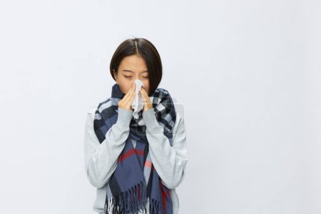 Foto de Mujer asiática gripe fría sosteniendo un pañuelo con la nariz llena de fiebre enferma por el virus en un fondo blanco, lugar de copia. Foto de alta calidad - Imagen libre de derechos