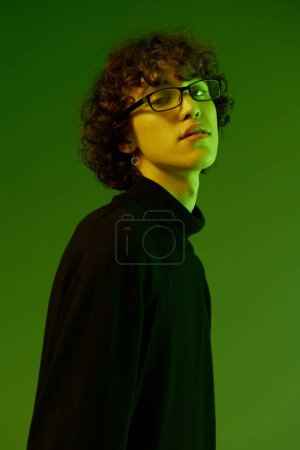 Foto de Hombre joven retrato en gafas moda felicidad y sonrisa, estilo de vida hipster, retrato fondo verde mezclado luz de neón, espacio de copia. Foto de alta calidad - Imagen libre de derechos