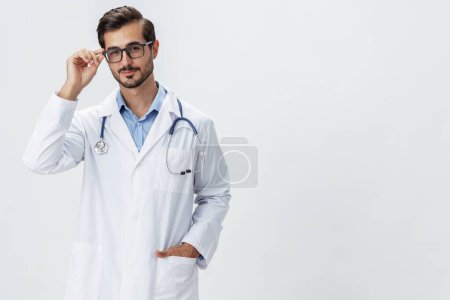 Foto de Hombre médico en bata blanca y gafas sonrisa muestra gestos de la mano signos sobre fondo blanco aislado mira en la cámara, espacio de copia, espacio para el texto, la salud. Foto de alta calidad - Imagen libre de derechos