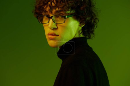 Foto de Retrato masculino joven de cerca en gafas de moda y estilo, estilo de vida hipster, retrato fondo verde mezclado luz de neón, espacio de copia. Foto de alta calidad - Imagen libre de derechos