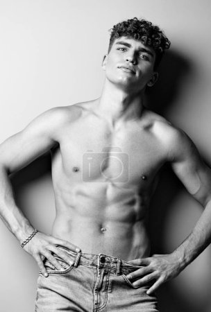 Foto de Hombre hermosa tendencia fuerte músculo atractivo elegante negro brazo jeans blanco ajuste fuerza - Imagen libre de derechos