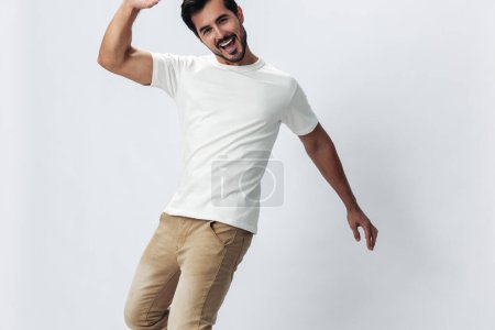 Foto de Hombre de moda saltando y corriendo en una camiseta blanca y jeans, sonrisa con dientes alegría sobre un fondo blanco aislado, estilo de ropa de moda, espacio de copia, espacio para el texto. Foto de alta calidad - Imagen libre de derechos