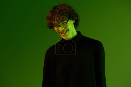 Foto de Hombre joven retrato en gafas moda felicidad y sonrisa, estilo de vida hipster, retrato fondo verde mezclado luz de neón, espacio de copia. Foto de alta calidad - Imagen libre de derechos