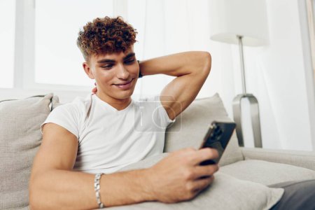 Photo for Man interior mockup message person mobile online sports student young smile sitting phone internet adult cyberspace text message home smartphone technology - Royalty Free Image