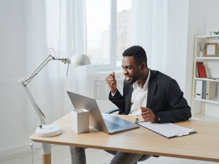 Photo for Man american sitting online male internet african businessman work copy office call student education distance space american computer modern freelancer job desk laptop - Royalty Free Image