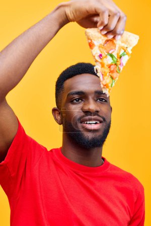 Photo for Hold man fast american meal background pizza food obesity millennial yellow african guy food afro concept delivery adult habit happy unhealthy funny black smile - Royalty Free Image