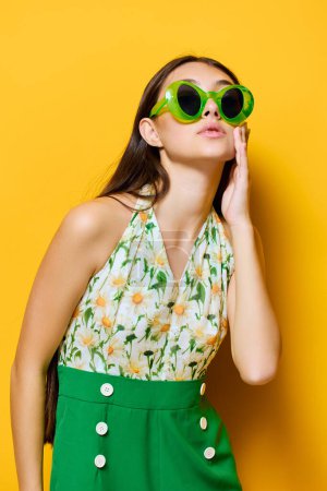 Foto de Mujer joven feliz linda emoción gafas de sol amarillo hermosa cara creativa sonrisa modelo mono delgado estilo elegante verde caucásico morena morena morena - Imagen libre de derechos