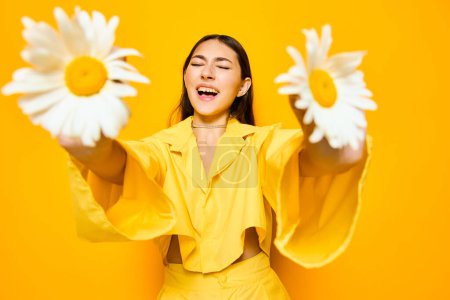 Téléchargez les photos : Femme joyeux caucasien attrayant portrait visage studio camomille jeune modèle fleur personne mode sourire jour bonheur liberté jolie beauté valentines jaune heureux - en image libre de droit