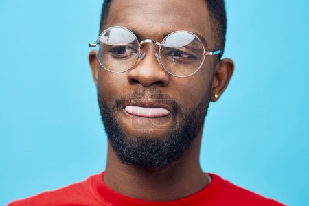 Téléchargez les photos : Homme américain sourire rouge style de vie beauté espace de mode à la mode élégant africain mâle lunettes bleu style vert copie portrait vêtements noir coiffure isolé modèle - en image libre de droit