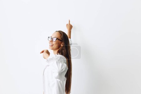 Foto de Mujer feliz con piel bronceada divirtiéndose en casa en un top blanco y camisa blanca con gafas contra una pared blanca, estilo de vida. Foto de alta calidad - Imagen libre de derechos