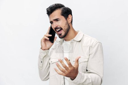 Photo for Closeup portrait man talking on the phone angry annoyance and quarrel on white isolated background, fashion style clothes, copy space, space for text. High quality photo - Royalty Free Image