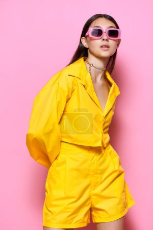 Foto de Mujer atractiva chica joven morena moderno traje romance estilo de vida aislado diversión felicidad gafas de sol moda amarillo belleza moda femenina hermoso fondo sonrisa - Imagen libre de derechos