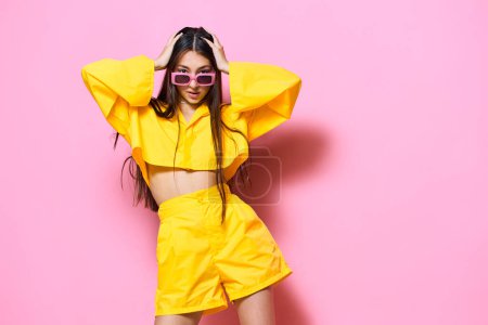 Photo for Attractive woman studio trendy person fashion lifestyle beautiful joy isolated summertime hair monochrome young dance smile sunglasses long glasses girl yellow beauty - Royalty Free Image