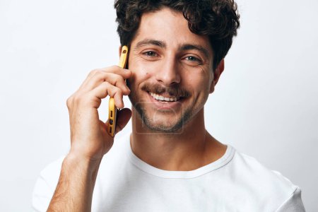 Photo for Phone man application chatting hipster caucasian handsome christmas technology communication confident portrait lifestyle cellphone texting message smart happy online white guy model shopping t-shirt - Royalty Free Image