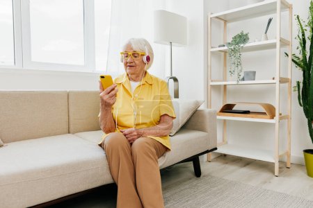 Téléchargez les photos : Heureuse femme âgée regardant dans le sourire d'appel vidéo téléphonique, la technologie pour la communication, intérieur moderne lumineux, mode de vie communication en ligne. Photo de haute qualité - en image libre de droit