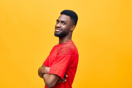 Téléchargez les photos : Homme à la mode beau fond africain coloré posant orange isolé occasionnel noir portrait gars américain mode joie dents attrayant sourire afro rouge américain heureux - en image libre de droit