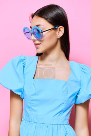 Photo for Brunette woman trendy beauty pink beautiful model vogue fashion young woman dress female relax day studio blue happy style stylish sunglasses pastel - Royalty Free Image