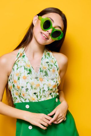 Foto de Cara mujer morena estilo amarillo traje lindo mujer sonrisa feliz joven moda caucásica emoción verde chica gafas de sol de moda elegante hermoso fondo - Imagen libre de derechos