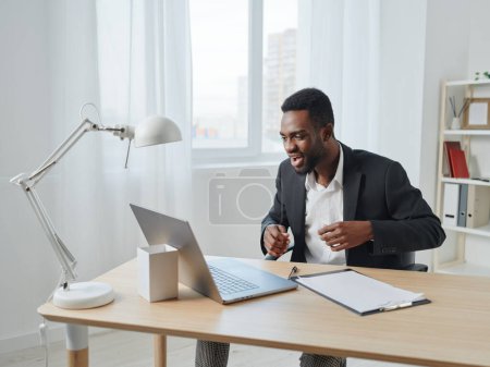 Téléchargez les photos : Homme web chat éducation africaine emploi ordinateur portable en ligne pigiste sourire bureau entrepreneur étudiant programmeur américain travailler homme d'affaires gestionnaire africain jeune - en image libre de droit